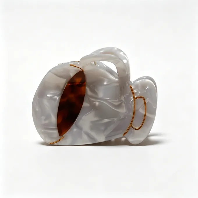 Pearl and tortoiseshell acetate joined in the sculptural loop claw clip