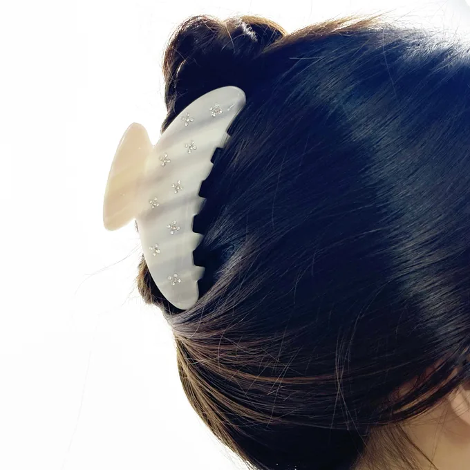 Rhinestone shark claw clip holding a bun