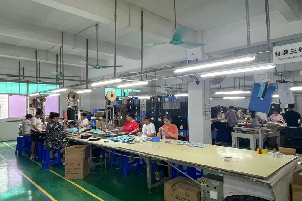 Workers packing finished hair accessories into retail cartons