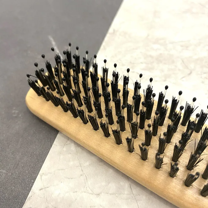 Macro of boar bristle and nylon pins set in rows on the styling brush