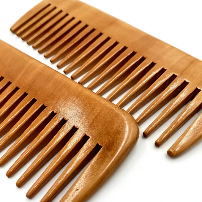 Close-up of sanded peachwood comb teeth showing natural grain, cut not moulded