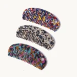 Three cellulose acetate combs of the same shape in three different sheet patterns stacked together