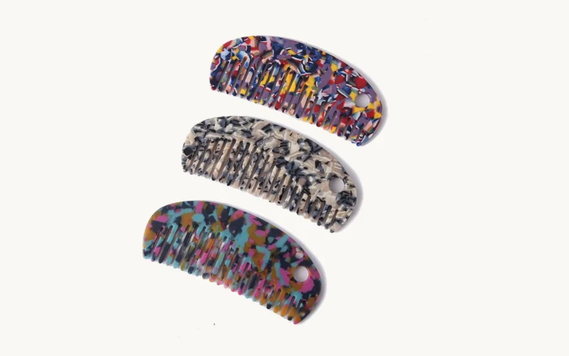 Three cellulose acetate combs of the same shape in three different sheet patterns stacked together