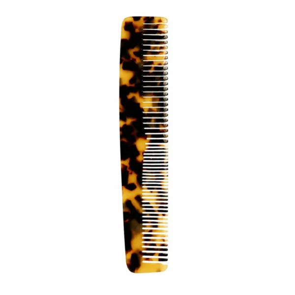Tortoiseshell cellulose acetate dressing comb standing upright with the teeth to the right, showing the fine-tooth and wide-tooth halves of the dual-density row