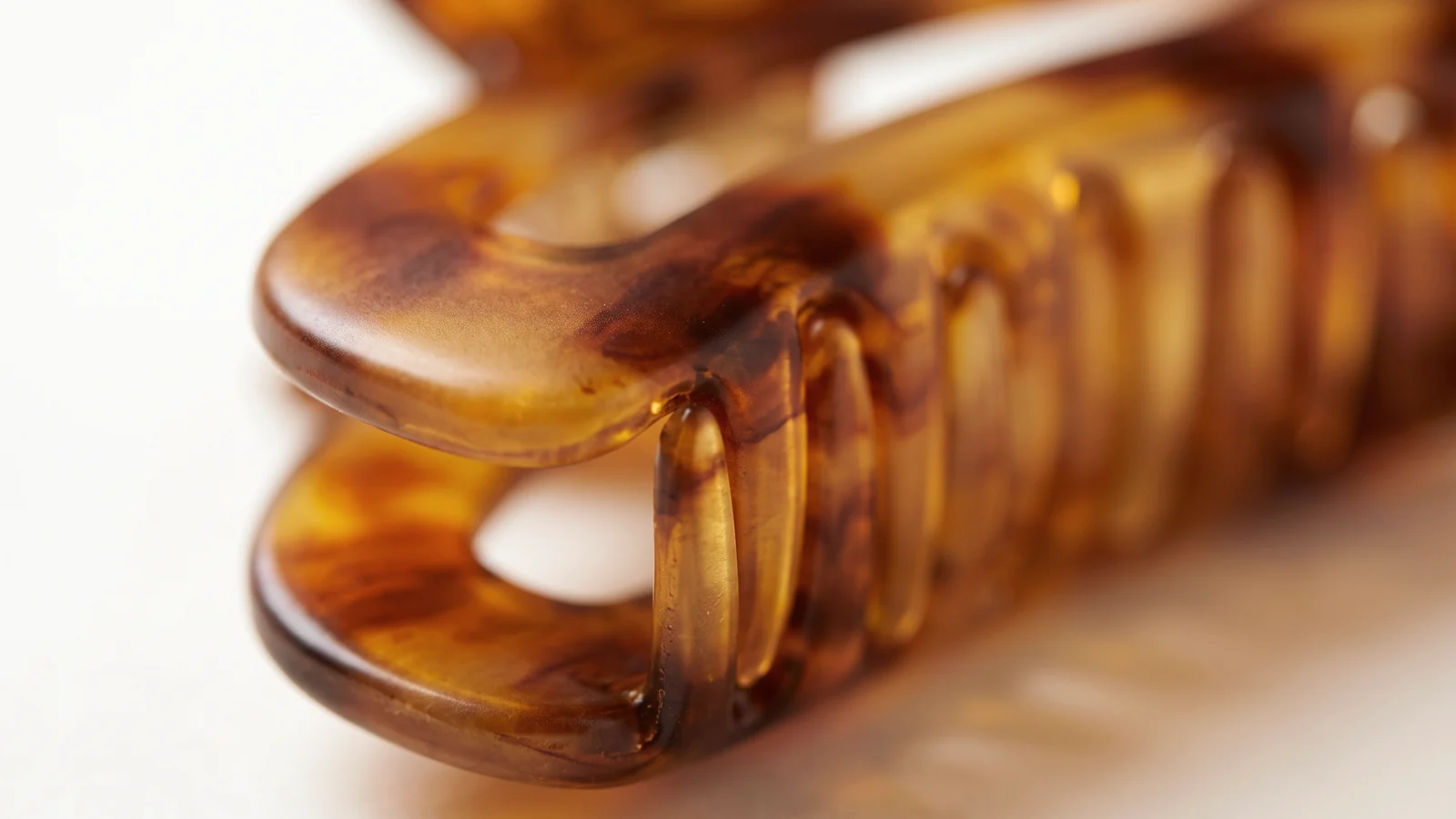 Macro detail of translucent amber cellulose acetate showing layered depth and satin sheen