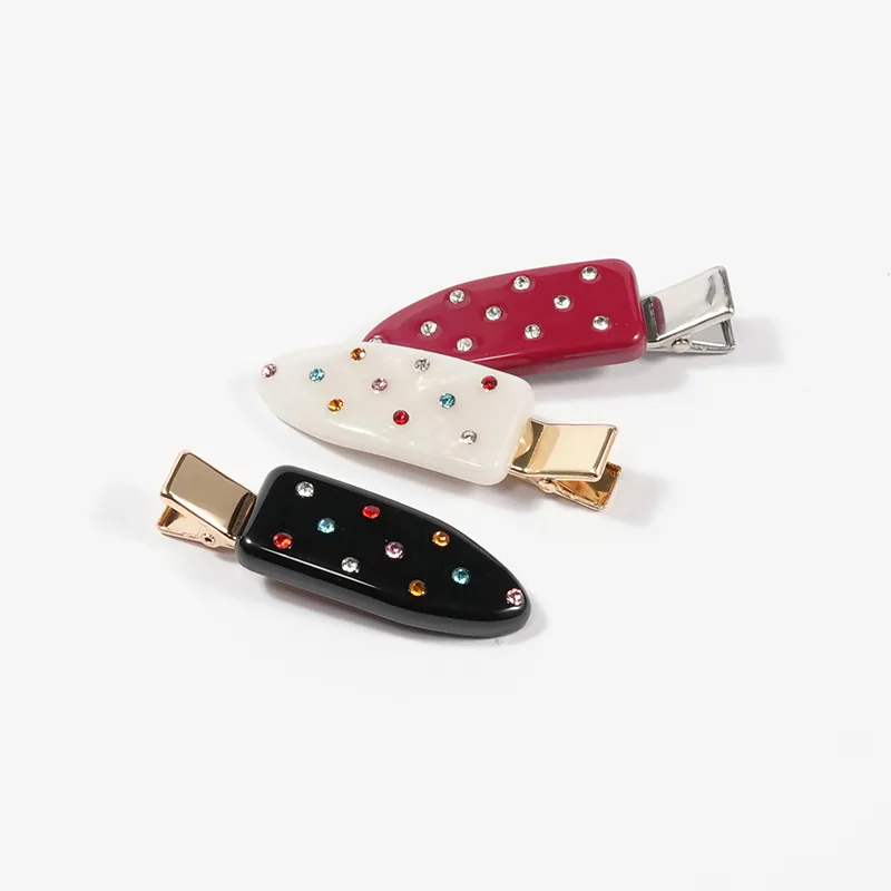 Three crystal-set acetate duckbill clips in black, white and red