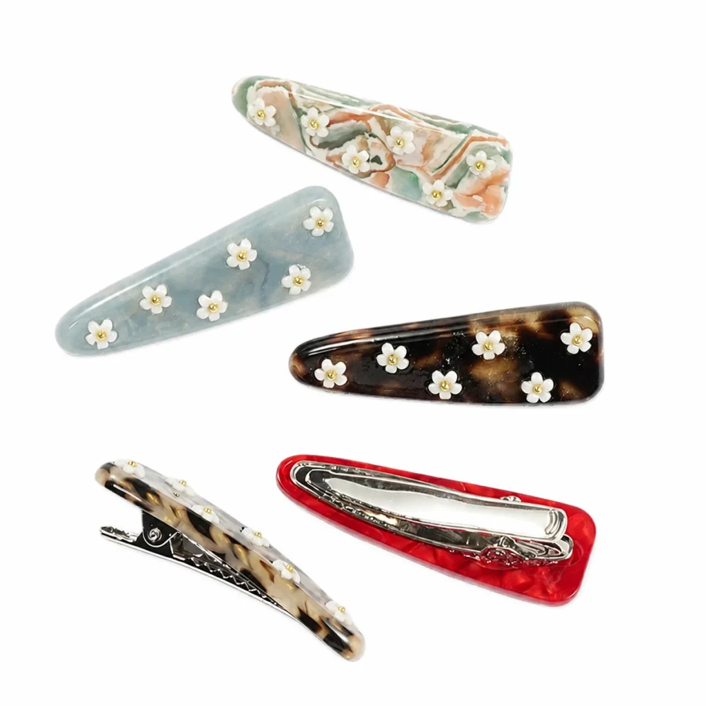Five daisy acetate snap clips with two turned to show the snap bar