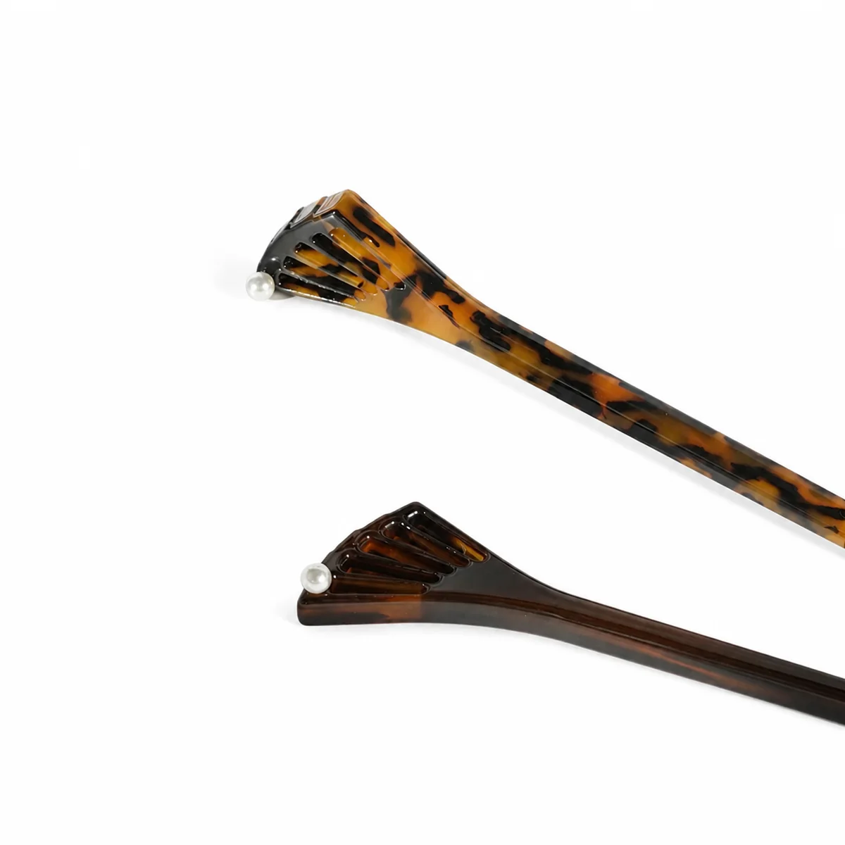Two fishtail hair sticks in tortoiseshell and dark brown, pearl set at the neck