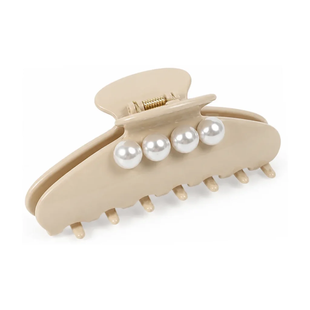 Sand beige acetate claw clip on a white background, set with a row of four large round pearls across the upper arm