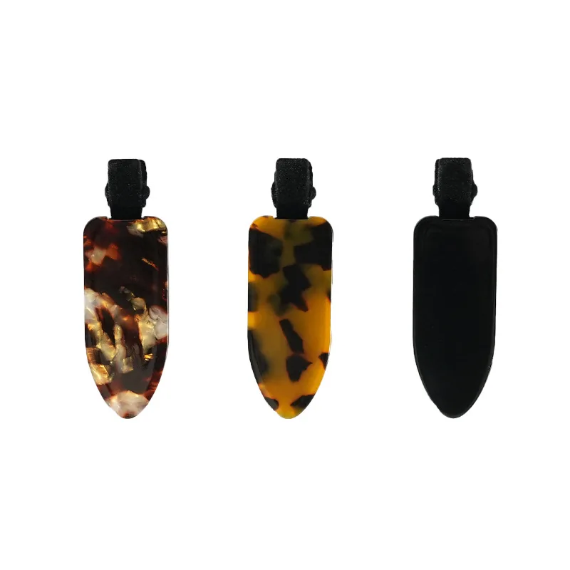 Three thick acetate side clips laid flat to show the colour range