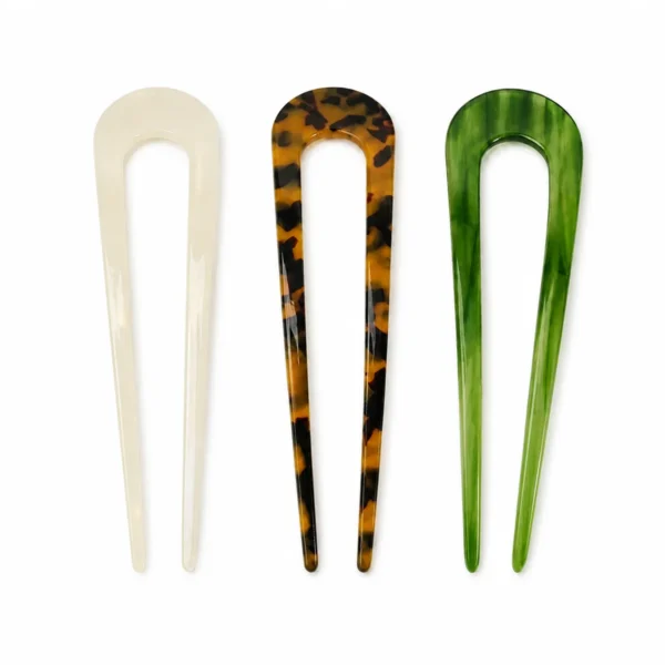 Three wide-U acetate hair forks upright side by side, all three colourways