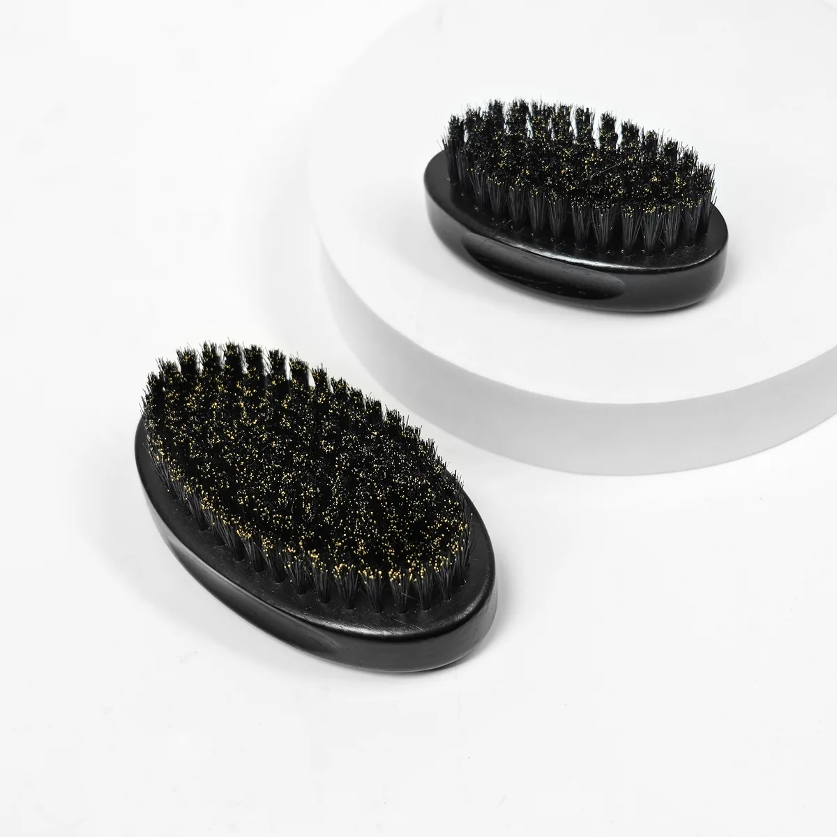 Large and small wooden beard brushes shown together for scale