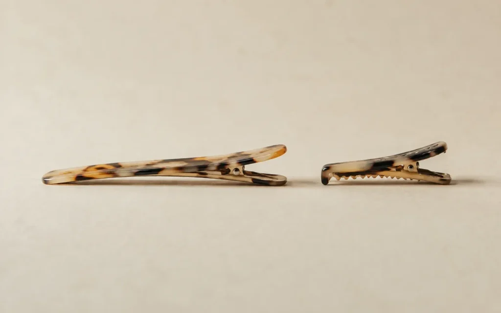 A duckbill clip and an alligator clip shown side by side in profile for comparison
