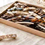 Wooden tray filled with mixed tortoiseshell and pearl acetate hair barrettes