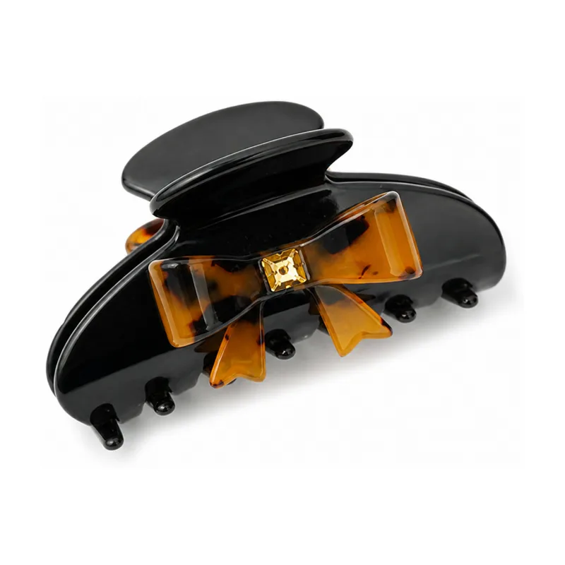 Gloss black acetate claw clip with a tortoiseshell bow and champagne crystal